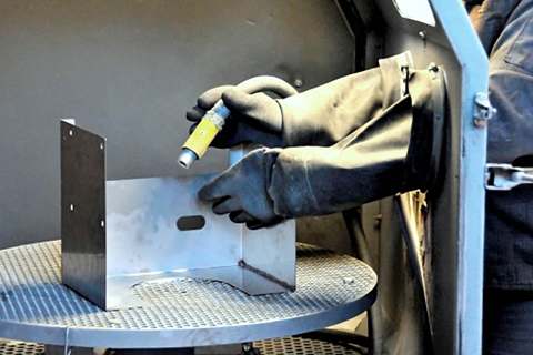 Metallteil beim Strahlen mit Glasperlen
